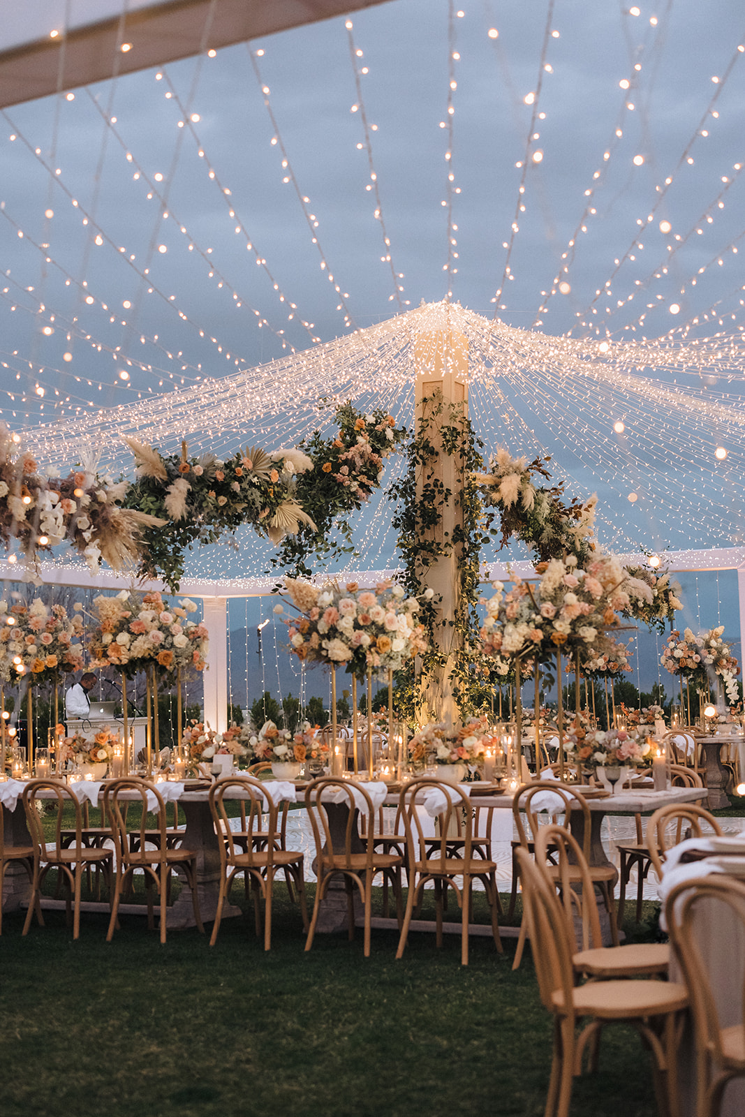 A Southern California outdoor wedding venue with twinkly lights and white and pastel florals.