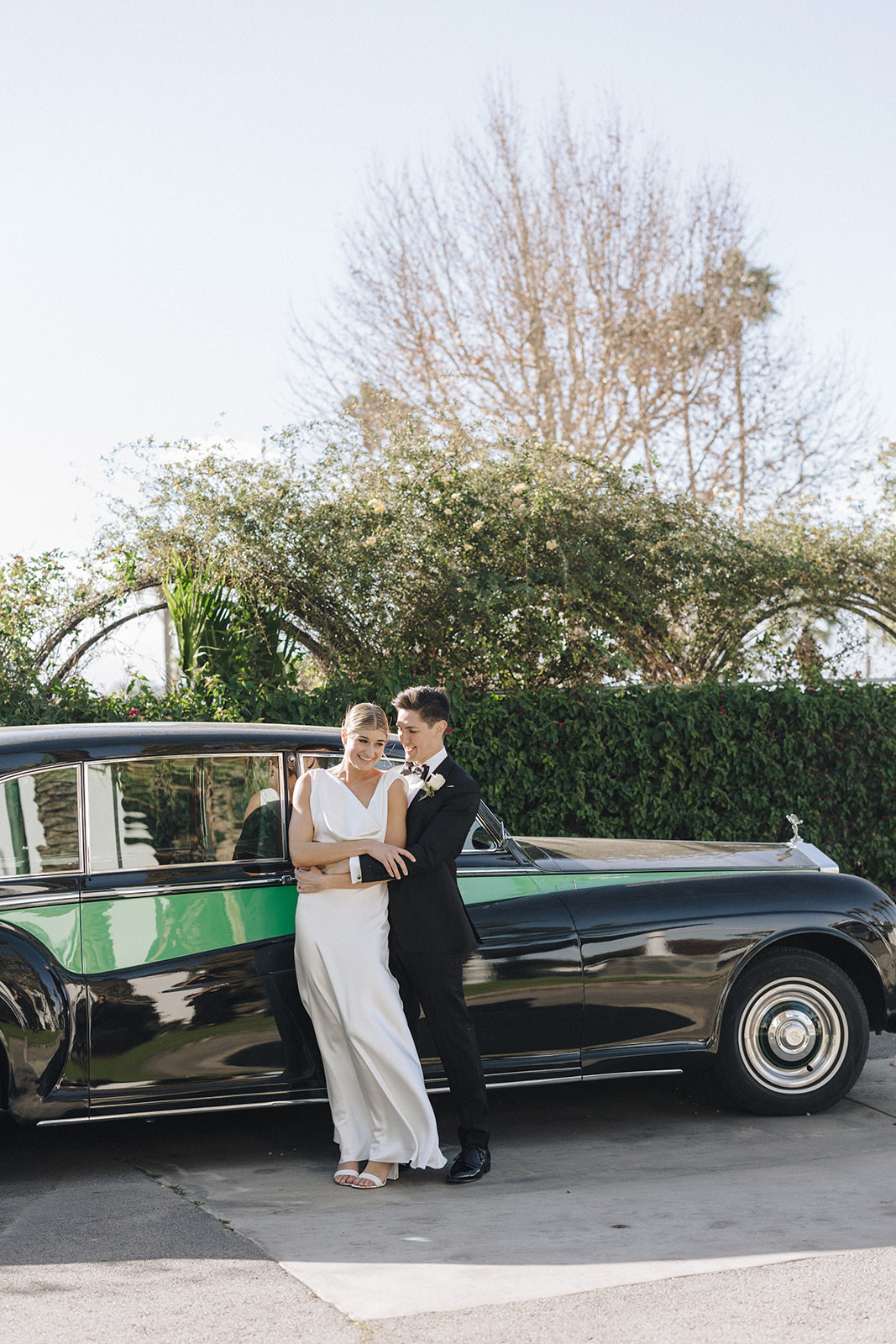 a female with blonde hair and a white wedding gown with her groom in an all black tux at their Coachella valley wedding