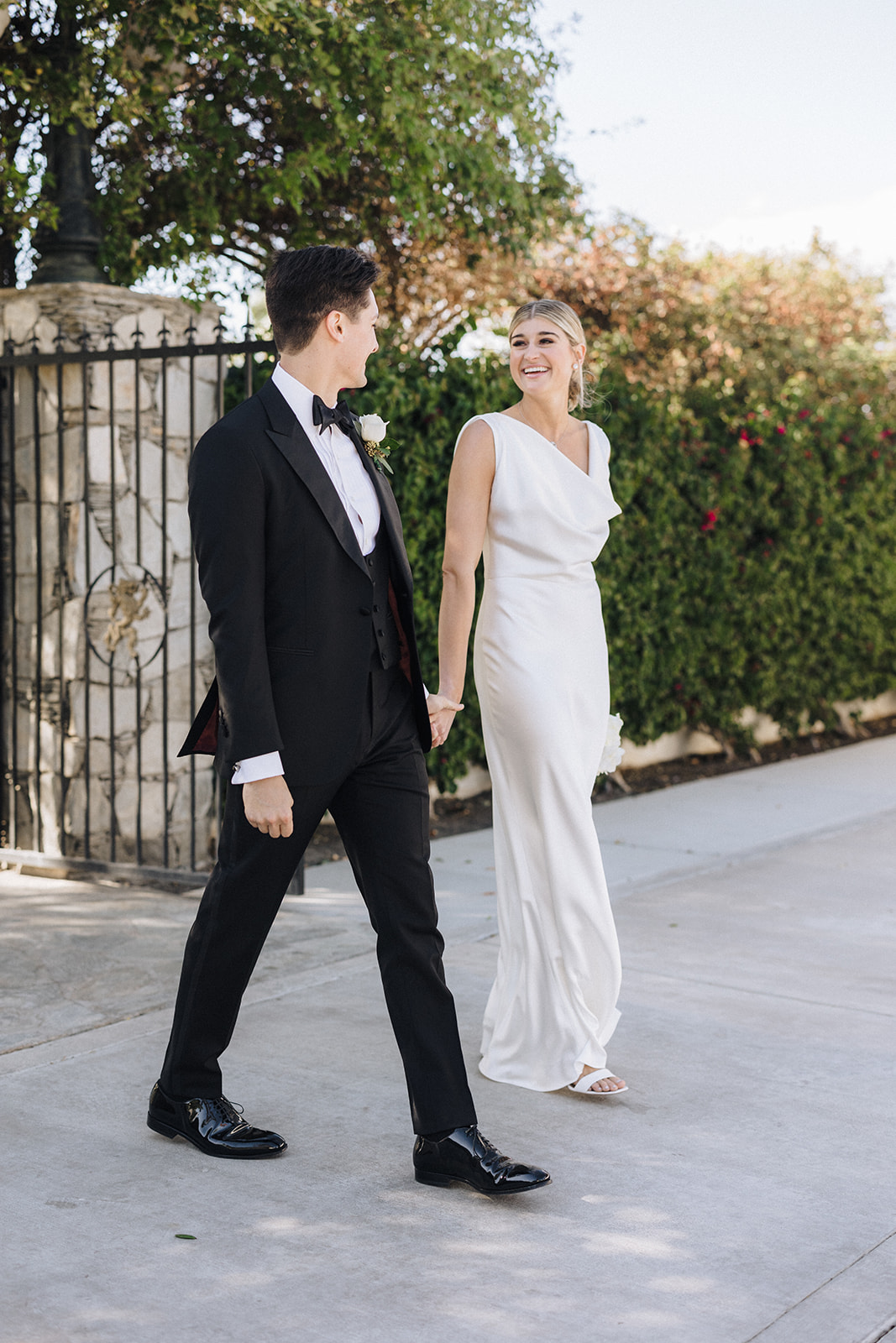 a female with blonde hair and a white wedding gown with her groom in an all black tux at their Coachella valley wedding
