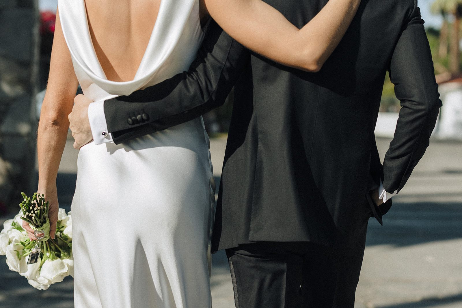 a female with blonde hair and a white wedding gown with her groom in an all black tux at their Coachella valley wedding