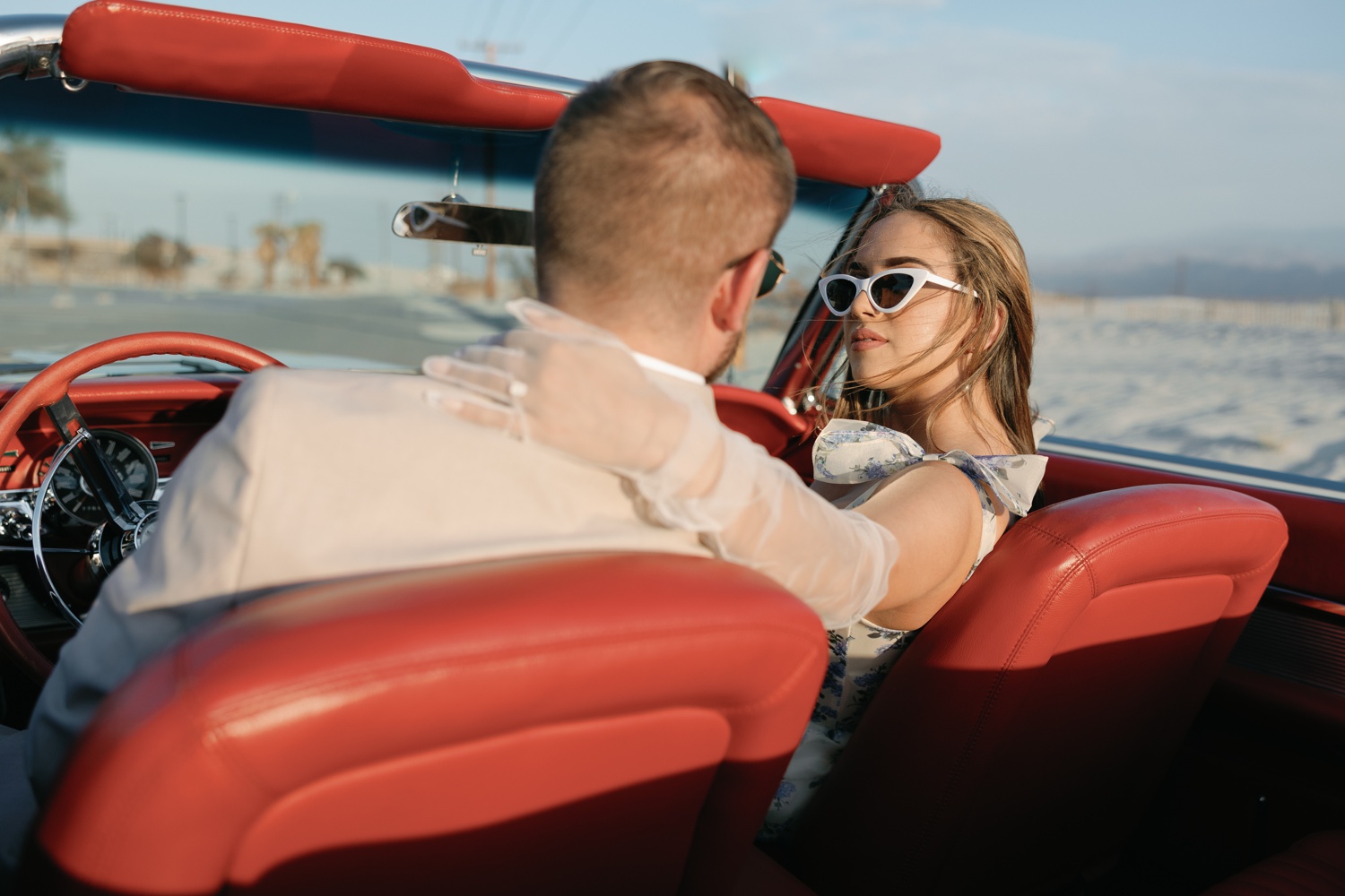 couple in a red vintage car for their California engagement photos